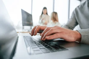 Profesional de recursos humanos creando un profesiograma en su ordenador durante una reunión de trabajo